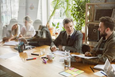 Bir grup genç iş adamı toplantı yapıyor, yaratıcı bir ofis.