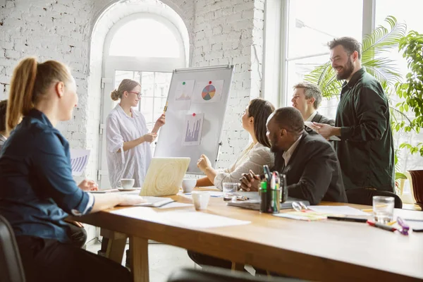 Grupo de jóvenes profesionales de la empresa que tienen una reunión, oficina creativa — Foto de Stock