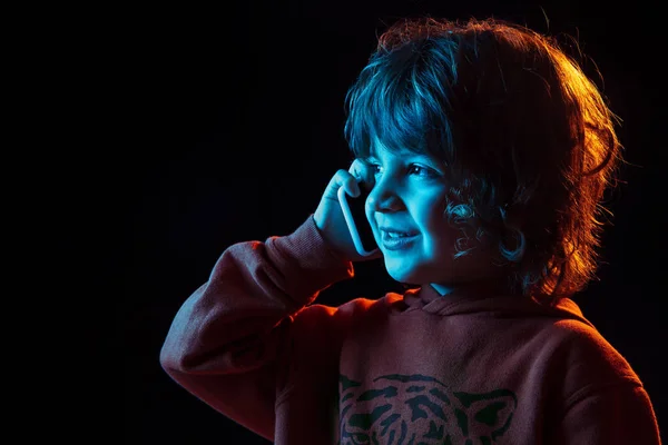 Кавказские мальчики портрет изолирован на темном фоне студии в неоновом свете — стоковое фото