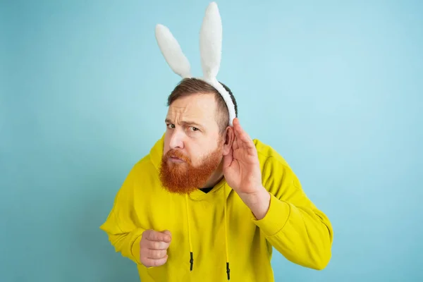 Hombre conejito de Pascua con emociones brillantes en el fondo del estudio azul — Foto de Stock