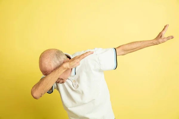 Kaukasische senior mans portret geïsoleerd op gele studio achtergrond — Stockfoto