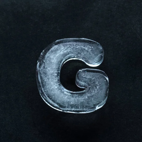 Alphabets letters made out of ice isolated on dark studio background — 스톡 사진