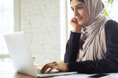 Çalışırken başörtüsü takan güzel bir Arap iş kadınının portresi