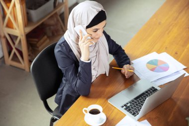 Çalışırken başörtüsü takan güzel bir Arap iş kadınının portresi