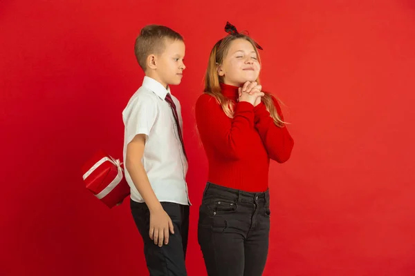 Γιορτή του Αγίου Βαλεντίνου, χαρούμενα καυκάσια παιδιά απομονωμένα σε κόκκινο φόντο — Φωτογραφία Αρχείου