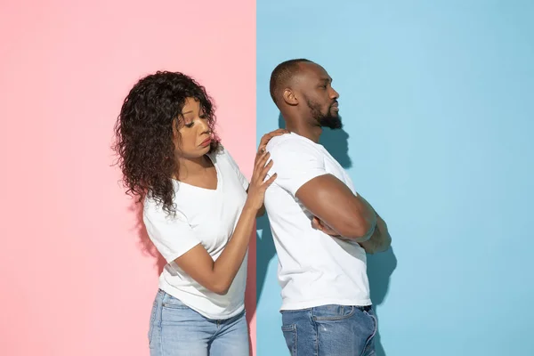 Jonge emotionele man en vrouw op roze en blauwe achtergrond — Stockfoto