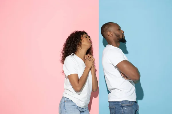 Jeune homme et femme émotionnelle sur fond rose et bleu — Photo