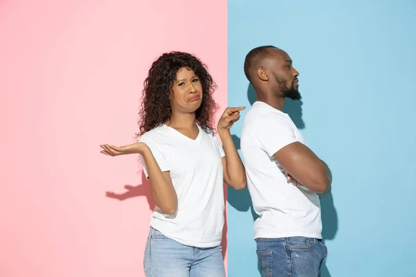 Jonge emotionele man en vrouw op roze en blauwe achtergrond — Stockfoto