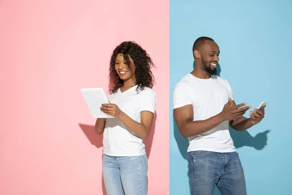 Ung emotionell man och kvinna på rosa och blå bakgrund — Stockfoto