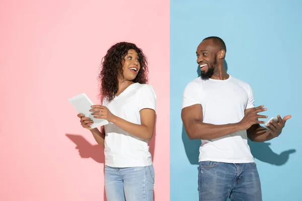 Jeune homme et femme émotionnelle sur fond rose et bleu — Photo