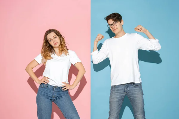 Jovem homem emocional e mulher no fundo rosa e azul — Fotografia de Stock