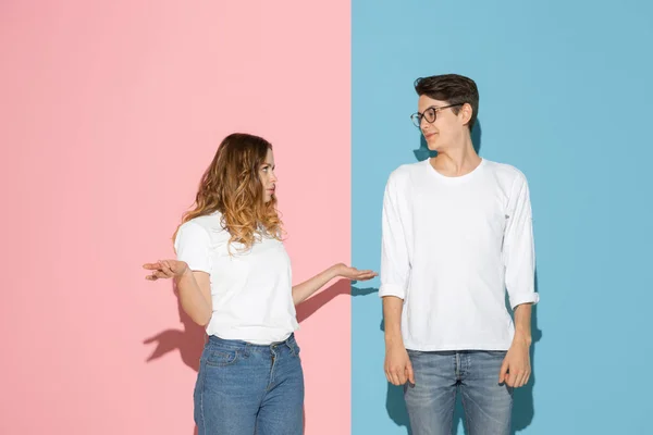 Joven hombre y mujer emocional sobre fondo rosa y azul — Foto de Stock