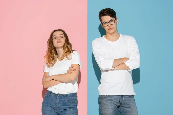 Jonge emotionele man en vrouw op roze en blauwe achtergrond — Stockfoto