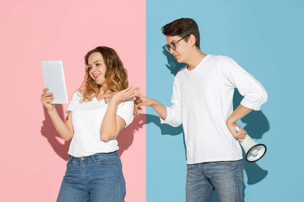 stock image Young emotional man and woman on pink and blue background