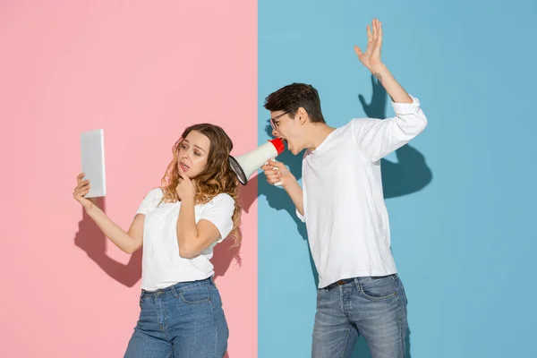 Junge emotionale Mann und Frau auf rosa und blauen Hintergrund — Stockfoto