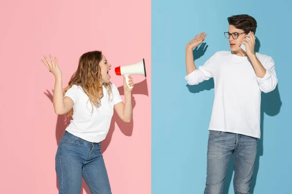 Junge emotionale Mann und Frau auf rosa und blauen Hintergrund — Stockfoto