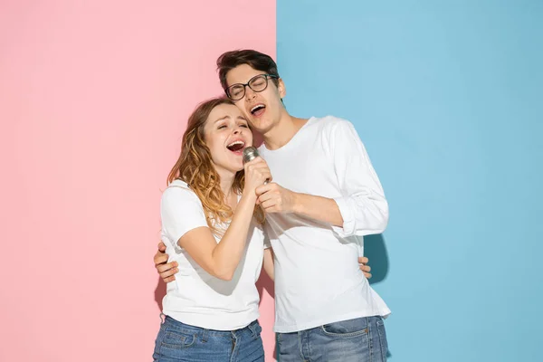 Jonge emotionele man en vrouw op roze en blauwe achtergrond — Stockfoto