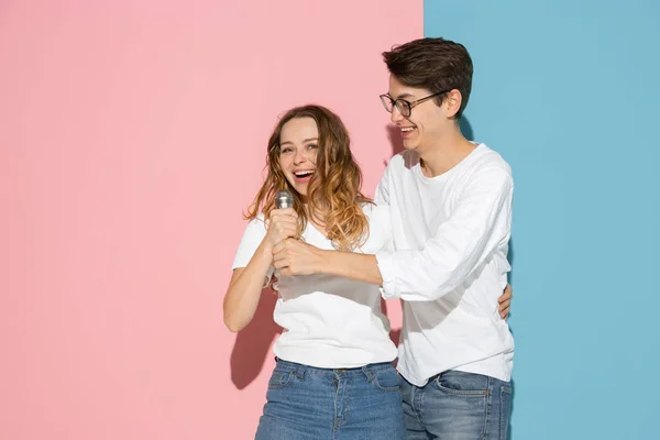 Fiatal érzelmi férfi és nő rózsaszín és kék háttér — Stock Fotó