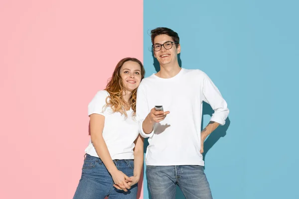 Молодой эмоциональный мужчина и женщина на розовом и синем фоне — стоковое фото