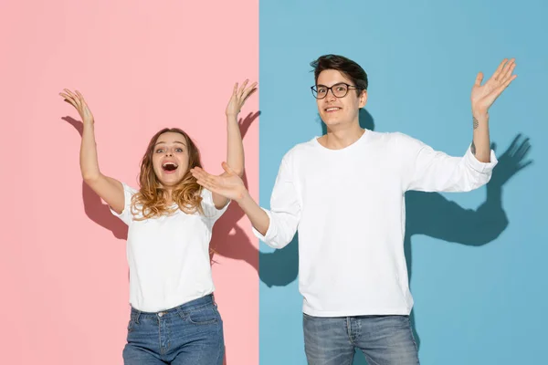 Jeune homme et femme émotionnelle sur fond rose et bleu — Photo