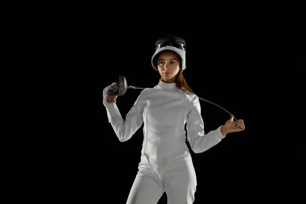 Tiener meisje in schermen kostuum met zwaard in de hand geïsoleerd op zwarte achtergrond — Stockfoto