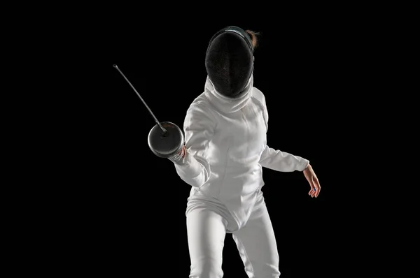 Adolescente chica en traje de esgrima con espada en mano aislado sobre fondo negro — Foto de Stock
