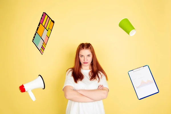 Caucasian young womans portrait on yellow background, too much tasks — 스톡 사진