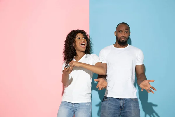 Jeune homme et femme émotionnelle sur fond rose et bleu — Photo