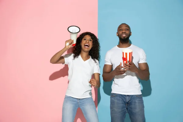 Jeune homme et femme émotionnelle sur fond rose et bleu — Photo