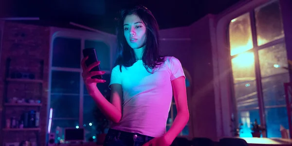 Cinematisch portret van knappe jonge vrouw in neon verlichte interieur — Stockfoto