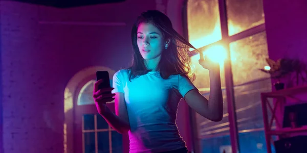 Retrato cinematográfico de bela jovem mulher em neon iluminado interior — Fotografia de Stock
