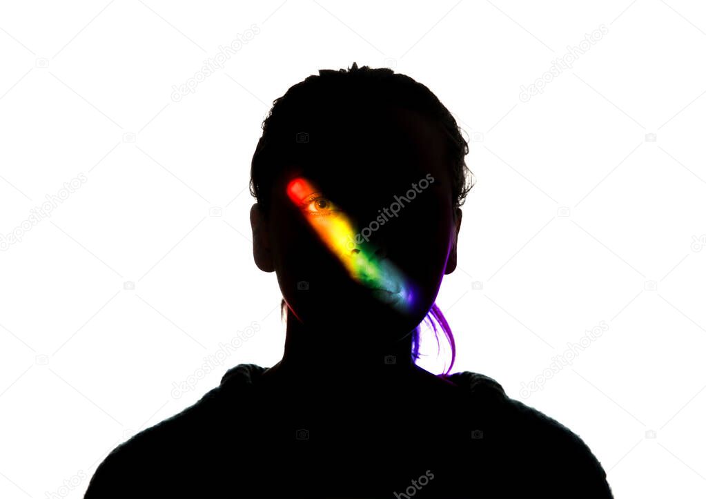 Dramatic portrait of a girl in the dark on white studio background with rainbow colored line