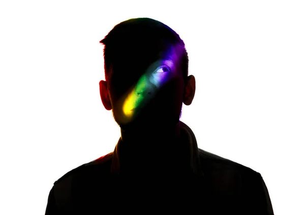 Dramatisch portret van een man in het donker op witte studio achtergrond met regenboog gekleurde lijn — Stockfoto