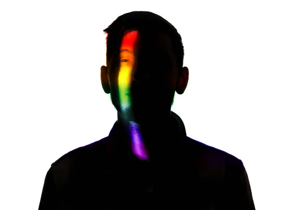 Dramatic portrait of a man in the dark on white studio background with rainbow colored line — 스톡 사진
