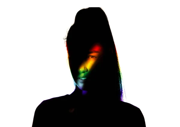 Драматический портрет девушки в темноте на белом фоне студии с радужной линией — стоковое фото