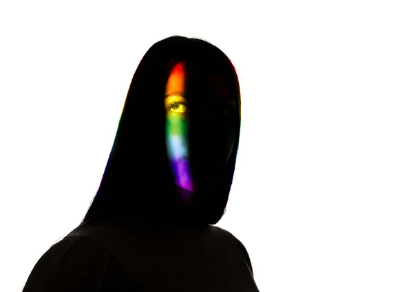 Retrato dramático de uma menina no escuro no fundo do estúdio branco com linha de cor do arco-íris — Fotografia de Stock
