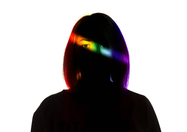 Dramatisches Porträt eines Mädchens im Dunkeln auf weißem Studiohintergrund mit regenbogenfarbener Linie — Stockfoto