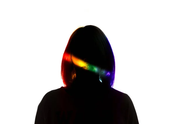 Dramatisches Porträt eines Mädchens im Dunkeln auf weißem Studiohintergrund mit regenbogenfarbener Linie — Stockfoto