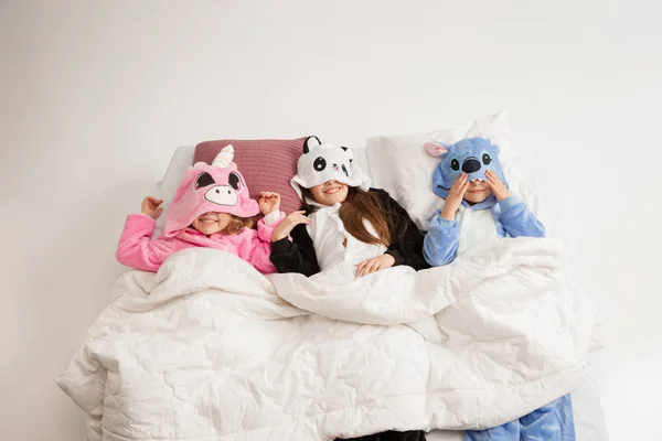 Los niños en pijamas suaves cálidos que tienen partido de colores brillantes jugando en casa —  Fotos de Stock