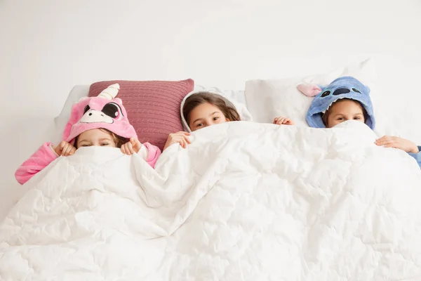 Los niños en pijamas suaves cálidos que tienen partido de colores brillantes jugando en casa —  Fotos de Stock