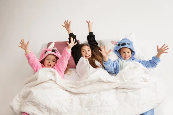 Children in soft warm pajamas having party colored bright playing at home — Stockfoto