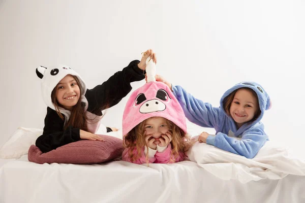 Los niños en pijamas suaves cálidos que tienen partido de colores brillantes jugando en casa —  Fotos de Stock