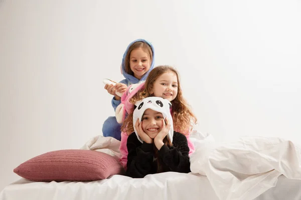 Los niños en pijamas suaves cálidos que tienen partido de colores brillantes jugando en casa —  Fotos de Stock