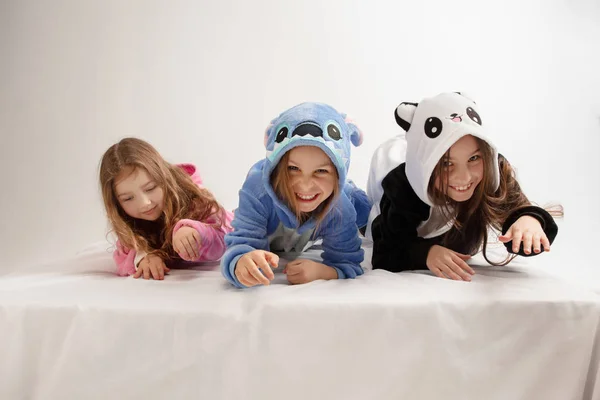 Los niños en pijamas suaves cálidos que tienen partido de colores brillantes jugando en casa —  Fotos de Stock
