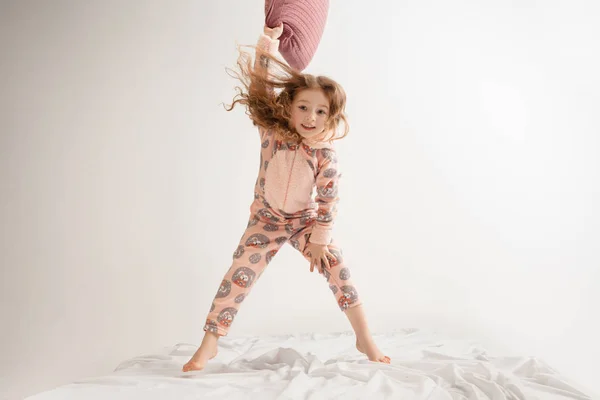 Маленькая девочка в мягкой теплая пижама с вечеринки цветной яркой игры дома — стоковое фото