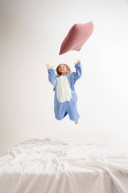 Little girl in soft warm pajama having party colored bright playing at home