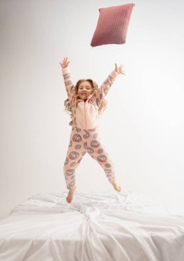 Little girl in soft warm pajama having party colored bright playing at home