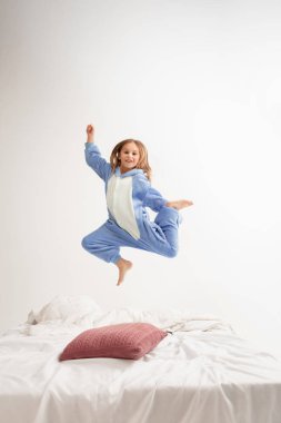 Little girl in soft warm pajama having party colored bright playing at home