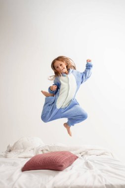 Little girl in soft warm pajama having party colored bright playing at home