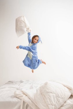 Little girl in soft warm pajama having party colored bright playing at home